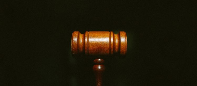 Redundancy concept. Know your rights sign. - A wooden gavel centered on a dark background with grain.