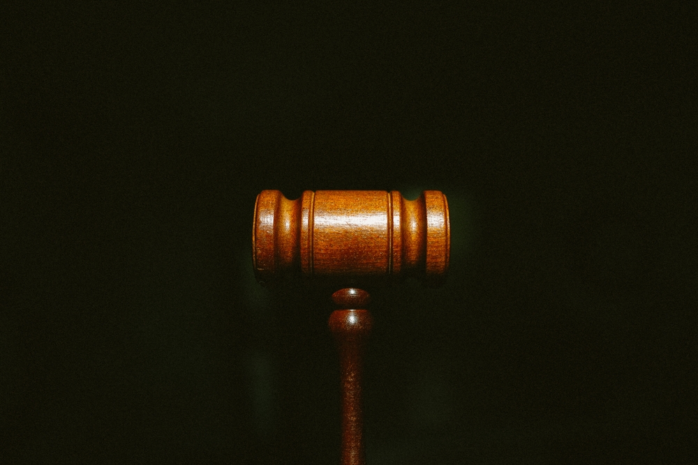 Redundancy concept. Know your rights sign. - A wooden gavel centered on a dark background with grain.